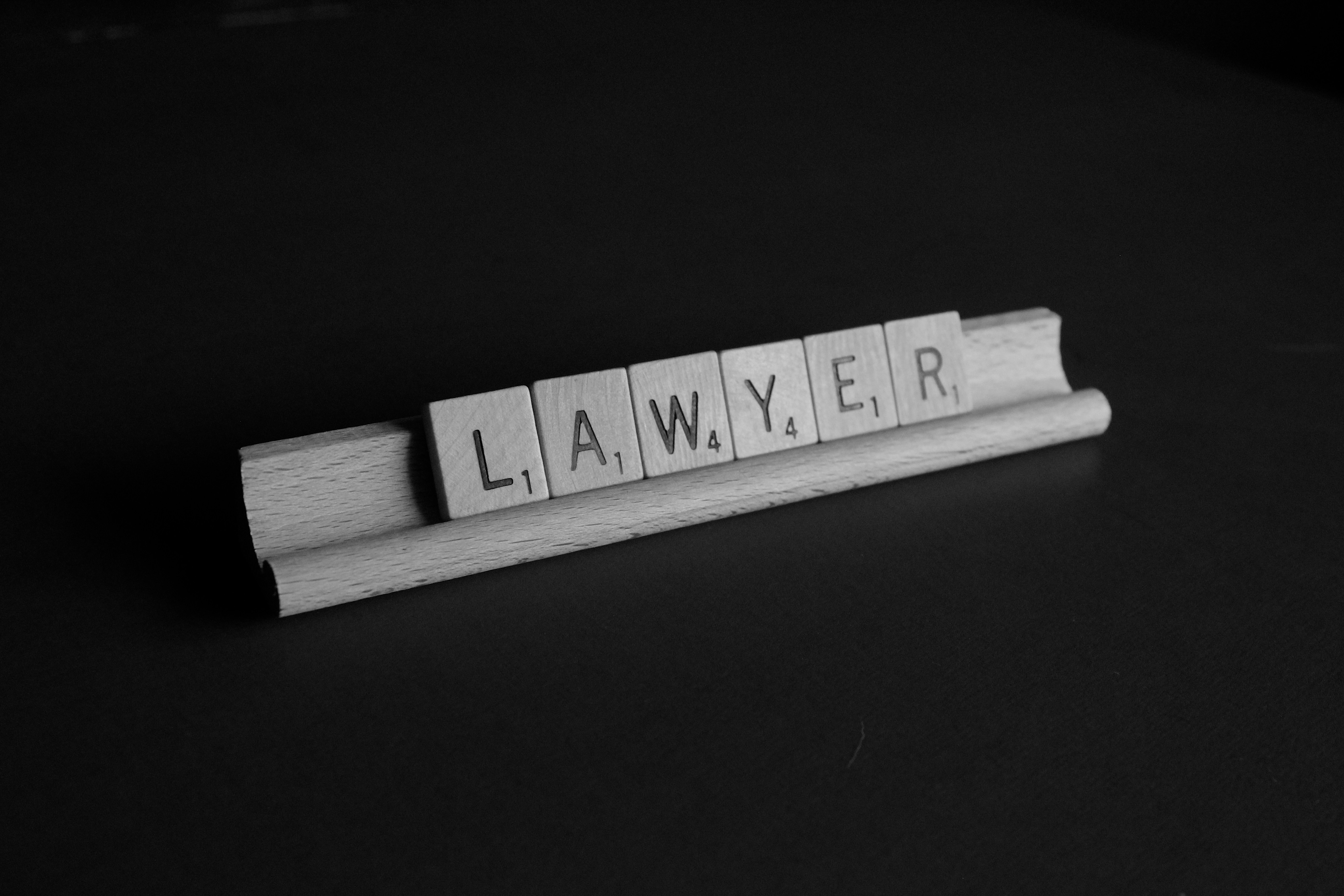 Pièces de scrabble qui forment le mot "lawyer" (avocat).